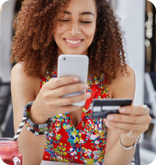 Mujer usando su teléfono y tarjeta bancaria